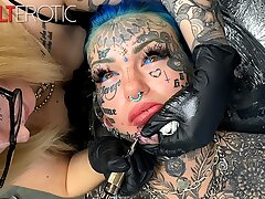 Stellar female caked in tats gets another tat on her face